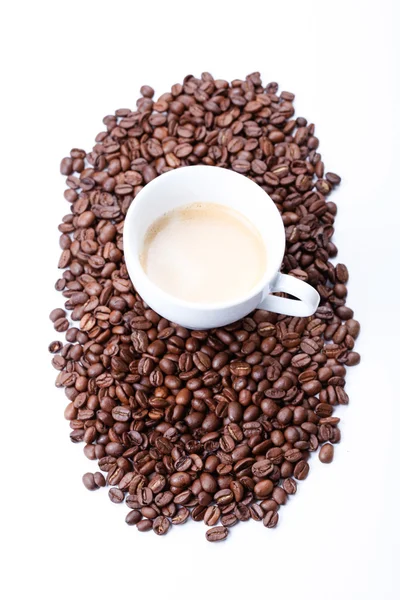Branco xícara de café em grãos de café fundo — Fotografia de Stock