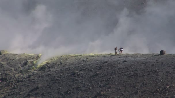 Turistas caminando en un borde del cráter del volcán — Vídeo de stock