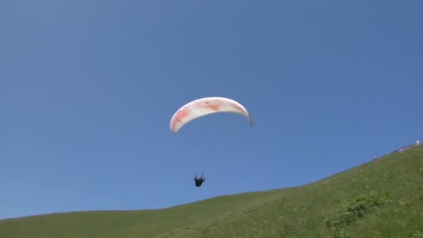 Kleurrijke paragliden op blauwe hemel — Stockvideo