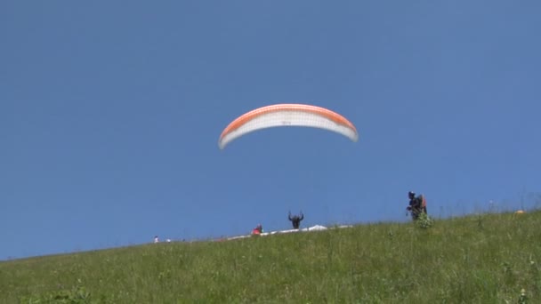 Πολύχρωμο αλεξίπτωτο πλαγιάς στο γαλάζιο του ουρανού — Αρχείο Βίντεο