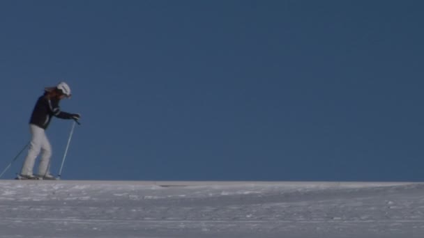 Um esquiador caminhando na neve — Vídeo de Stock