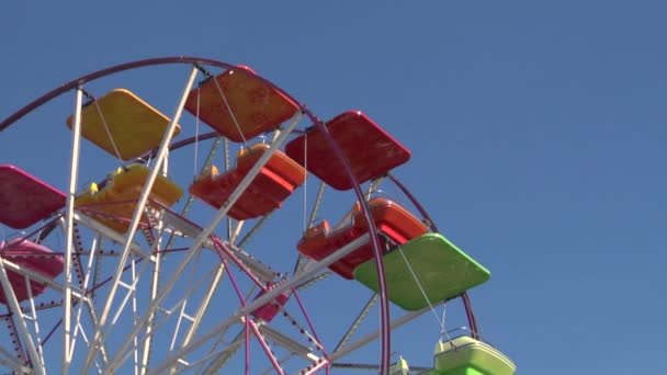 Ferris wheel with multicolored cabins in amusement park — Stock Video