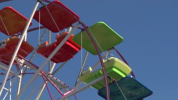 Ferris wheel with multicolored cabins in amusement park — Stock Video