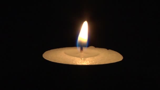 Nahaufnahme brennender Kerze isoliert auf schwarzem Hintergrund — Stockvideo