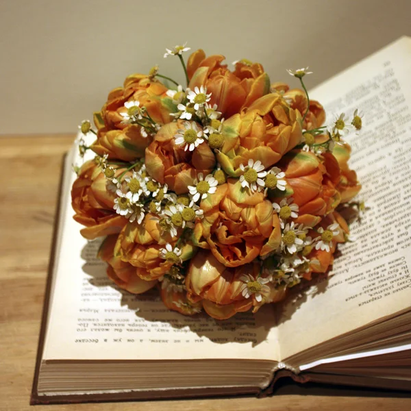 Un livre ouvert avec un bouquet de fleurs — Photo