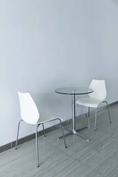 Kursi putih dan meja kaca dengan latar belakang bersih — Stok Foto