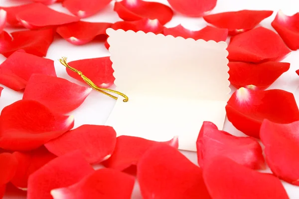 Rosas rojas con una etiqueta de regalo en blanco . — Foto de Stock
