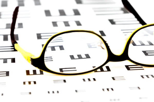 Glasses on vision test chart — Stock Photo, Image