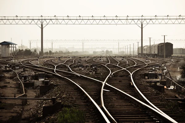 Железная дорога в тумане на станции, открытый пейзаж — стоковое фото