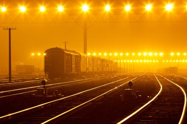 Gün batımında konteynırla birlikte kargo treni platformu