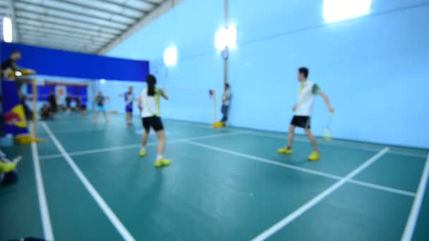 Terrains de badminton avec des joueurs en compétition en salle . — Video