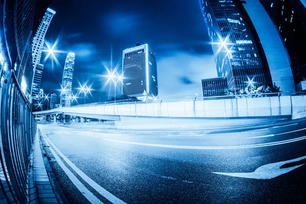 Trafik med oskärpa ljus genom staden på natten — Stockfoto