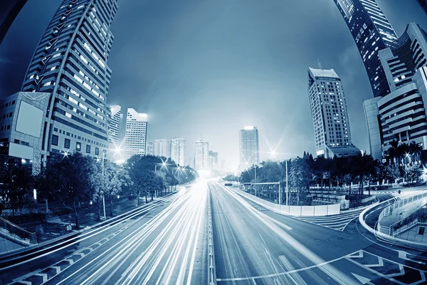 Tráfico con luz borrosa a través de la ciudad por la noche — Foto de Stock