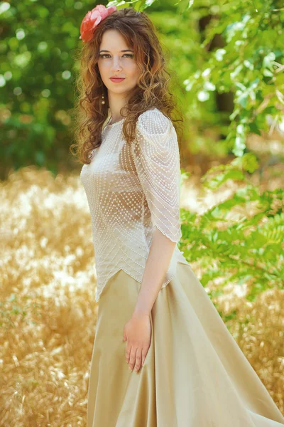 Una giovane donna con lunghi capelli ondulati in un abito leggero intelligente — Foto Stock