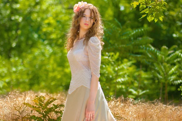 Una giovane donna con lunghi capelli ondulati in un abito leggero intelligente — Foto Stock