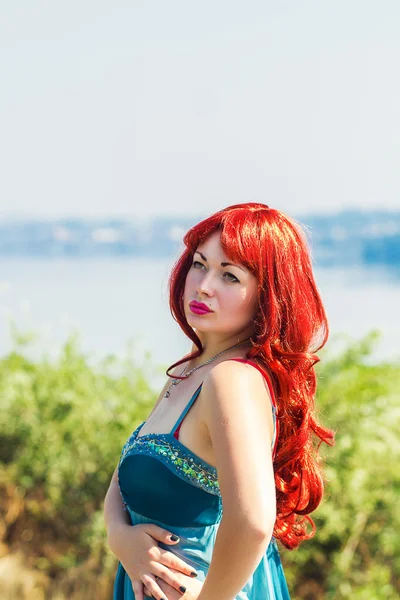 Retrato de una hermosa joven con el pelo rojo sobre un fondo de la naturaleza —  Fotos de Stock