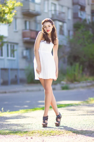 Portrait of a beautiful brunette girl in a short dress with bright makeup — Stock Photo, Image