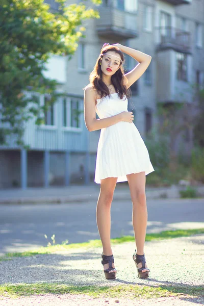 Porträtt av en vacker brunett flicka i en kort klänning med ljusa makeup — Stockfoto