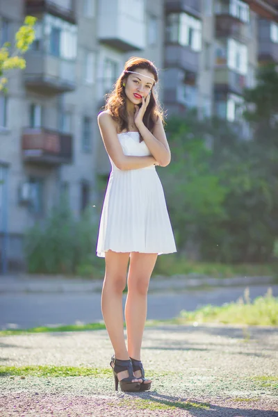 Portrait of a beautiful brunette girl in a short dress with bright makeup — Stock Photo, Image