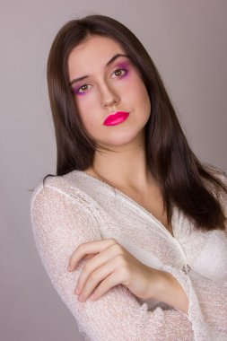 Beyaz bir bluz giyen güzel bir genç esmer kadının pembe dudaklar, duygusal portre Studio