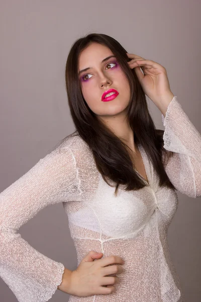 Studio ritratto emotivo di una bella giovane donna bruna con le labbra rosa, indossando una camicetta bianca — Foto Stock
