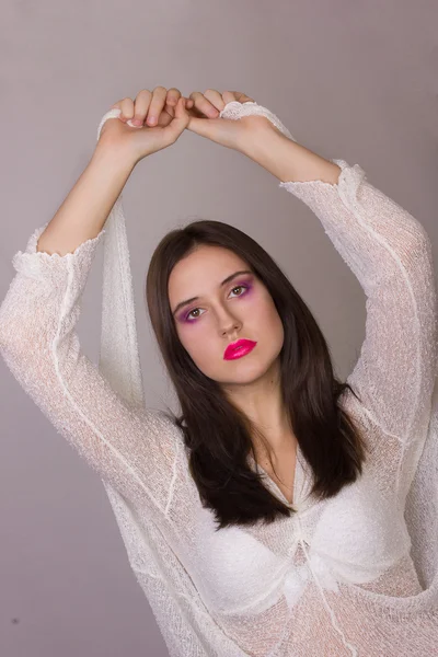 Studio känslomässiga porträtt av en vacker ung brunett kvinna med rosa läppar, klädd i en vit blus — Stockfoto
