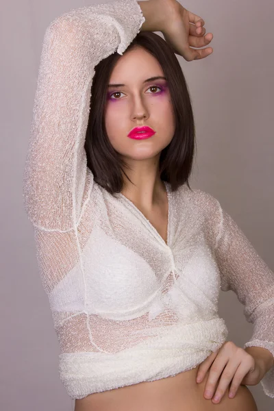 Estúdio retrato emocional de uma bela jovem morena com lábios cor de rosa, vestindo uma blusa branca — Fotografia de Stock