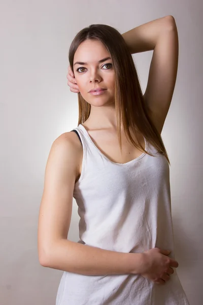 一个漂亮的年轻女人在自然妆容和棕色直发件白色 t 恤的肖像 — 图库照片