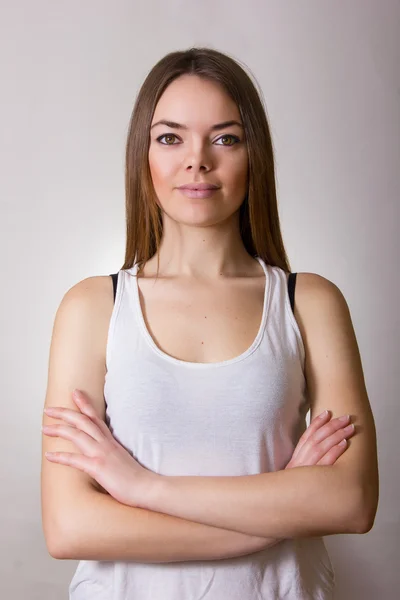 Portrait of a beautiful young woman in a white T-shirt with natural make-up and straight brown hair — Stock Photo, Image