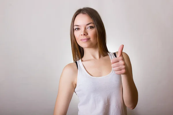 Retrato de uma bela jovem mulher em uma camiseta branca com maquiagem natural e cabelo castanho liso — Fotografia de Stock