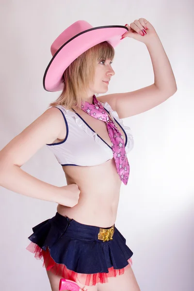Beautiful young blonde woman in a pink cowboy suit — Stock Photo, Image