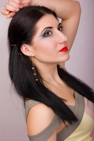 Retrato de una hermosa joven morena en estudio con maquillaje de noche brillante en un vestido beige corto —  Fotos de Stock