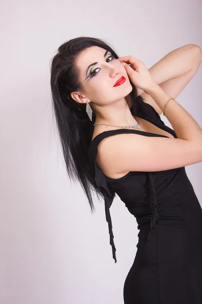 Vacker smal ung brunett kvinna i svart klänning och smycken — Stockfoto