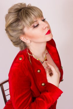 seksi işletme stilde kısa saçlı güzel bir genç sarışın kız portresi. kırmızı bir ceket ve kırmızı pantolon giymiş bir kadın.