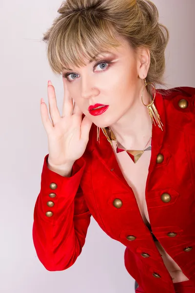 Muotokuva kaunis nuori blondi tyttö lyhyet hiukset seksikäs liike tyyliin. Nainen punaisessa takissa ja punaisissa housuissa . — kuvapankkivalokuva