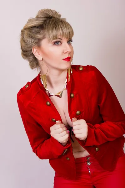 Portret van een mooie jonge blonde meisje met kort haar in een sexy business-stijl. een vrouw gekleed in een rood jasje en rode broek. — Stockfoto