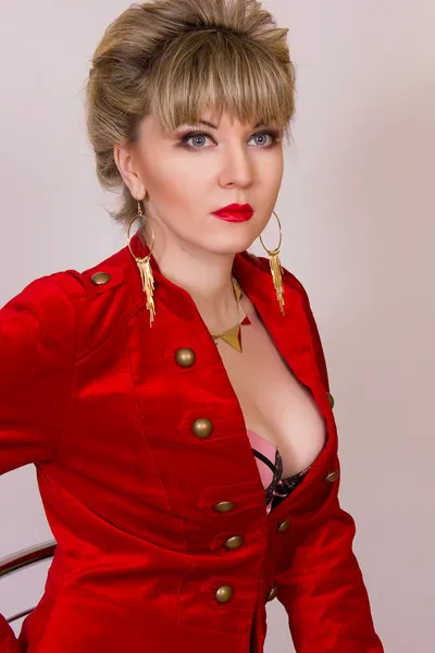 Muotokuva kaunis nuori blondi tyttö lyhyet hiukset seksikäs liike tyyliin. Nainen punaisessa takissa ja punaisissa housuissa . — kuvapankkivalokuva