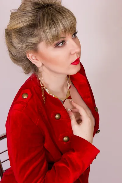 Porträt eines schönen jungen blonden Mädchens mit kurzen Haaren im sexy Business-Stil. eine Frau in roter Jacke und roter Hose. — Stockfoto