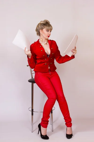 Portrait of a beautiful young blonde girl with short hair in a sexy business style. A woman dressed in a red jacket and red pants. — Stock Photo, Image