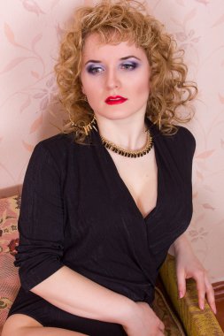 Retro tarzında güzel sarışın bir kadının portresi. Siyah elbiseli bir kız, duygularını belli ediyor.