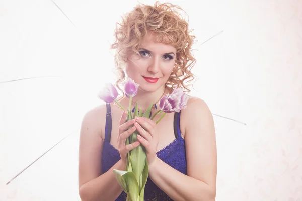 Retrato de una hermosa joven rubia en lencería. Chica con el pelo rizado posando sobre un hermoso fondo en el interior — Foto de Stock