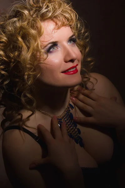 Portret van een mooie jonge blonde vrouw met krullend haar in lingerie poseren in de schaduw — Stockfoto