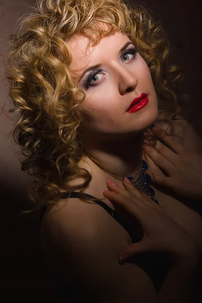 Retrato de una hermosa joven rubia con el pelo rizado en lencería posando en las sombras —  Fotos de Stock
