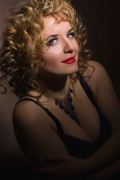 Porträt einer schönen jungen blonden Frau mit lockigem Haar in Dessous, die im Schatten posiert — Stockfoto