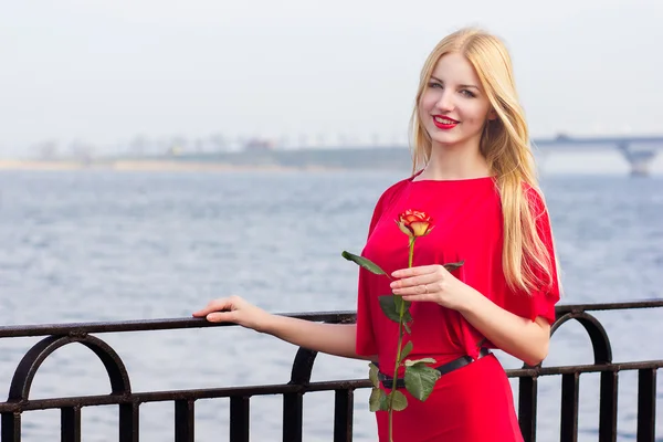 Портрет блондинки в красном макси платье на открытом воздухе — стоковое фото