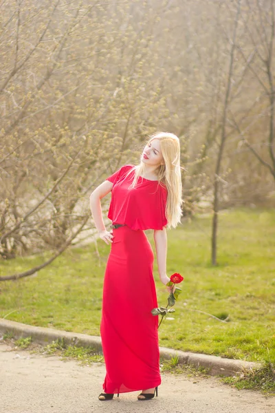 Portrait of blond woman in red maxi dress outdoor — Stock Photo, Image