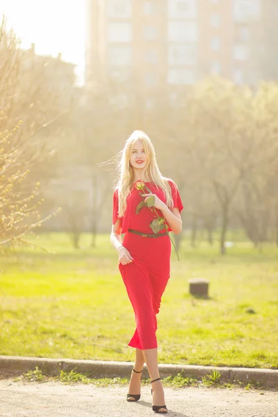 Porträtt av blond kvinna i röd maxi klänning utomhus — Stockfoto