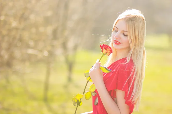 Portret van blonde vrouw in rood maxi jurk buiten — Stockfoto