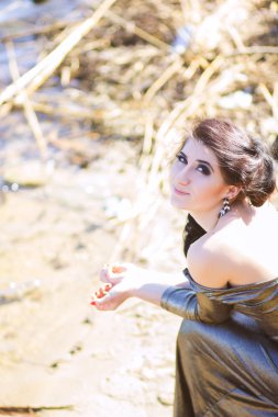 uzun siyah Abiye sahilde lüks kadın. Deniz kenarındaki güzel genç kız.