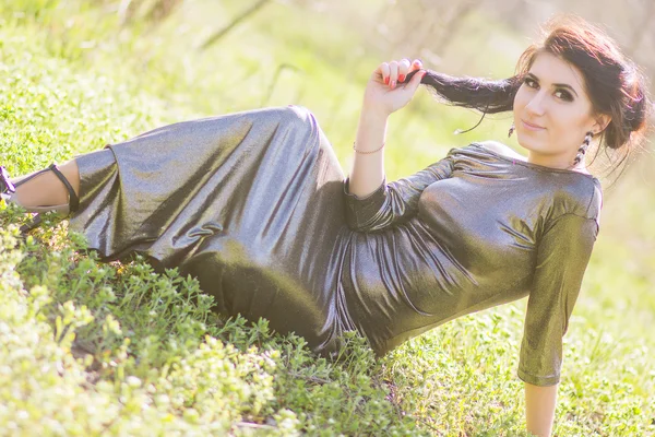 Luxury woman in a long black evening dress in the park — Stock Photo, Image